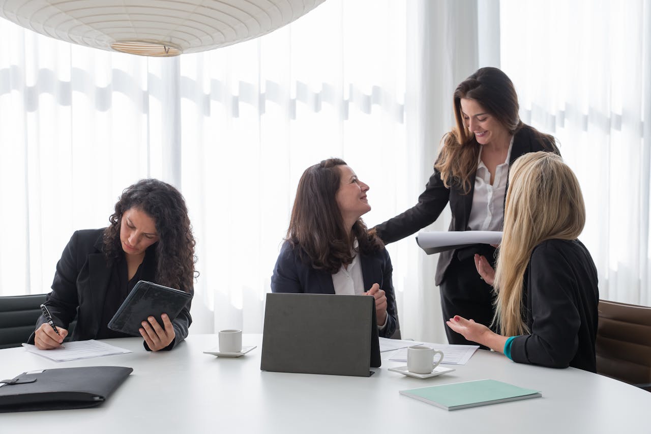 Business meeting with women in corporate attire engaged in discussion and planning indoors.